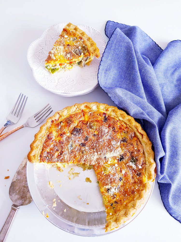 Circular image linking to quiche recipes, showing a golden brown slice of spinach and cheese quiche.