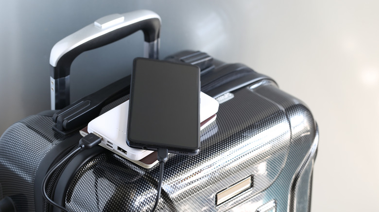 A power bank and passport on luggage.