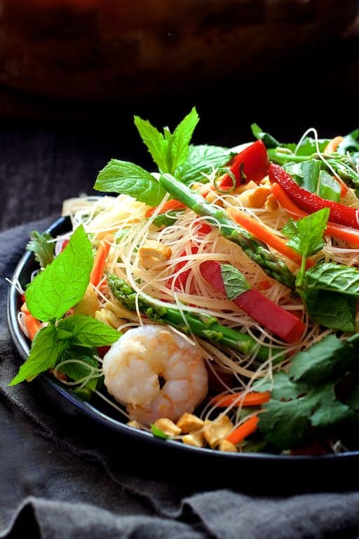 Photo of Vietnamese Spring Roll Salad on black plate garnished with mint sprigs.