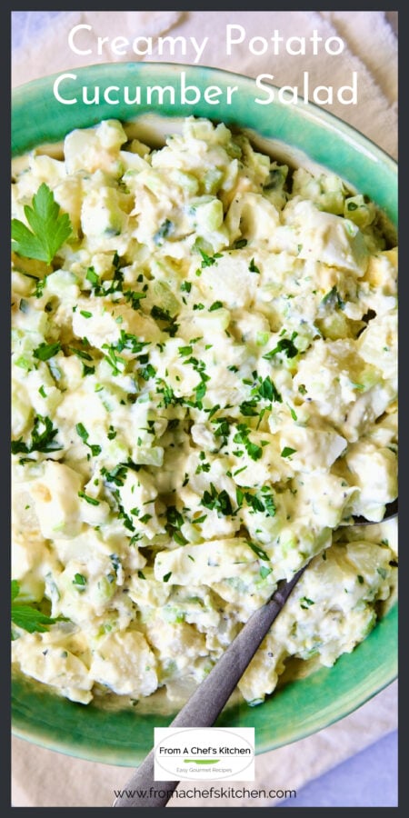 Creamy Potato Cucumber Salad in green bowl with serving spoon.