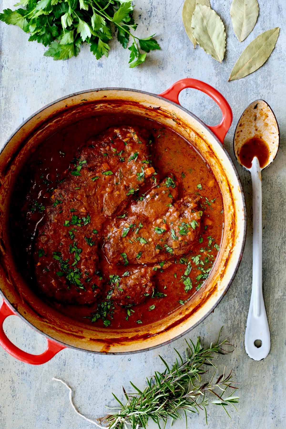 Italian Pot Roast (Stracotto) in red enamel cast iron Dutch oven after being braised.