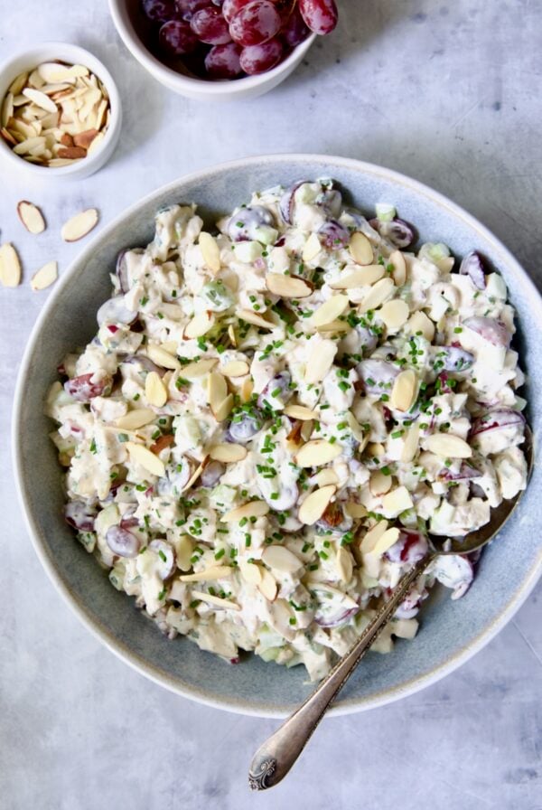 Chicken salad in blue bowl with serving spoon.