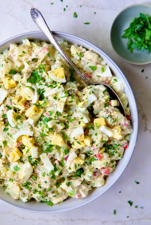 Potato Salad with Horseradish Dressing in light blue bowl with serving spoon.