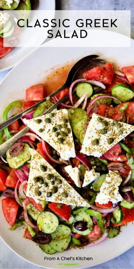 Pinterest graphic for Classic Greek Salad showing it on an oval white platter.
