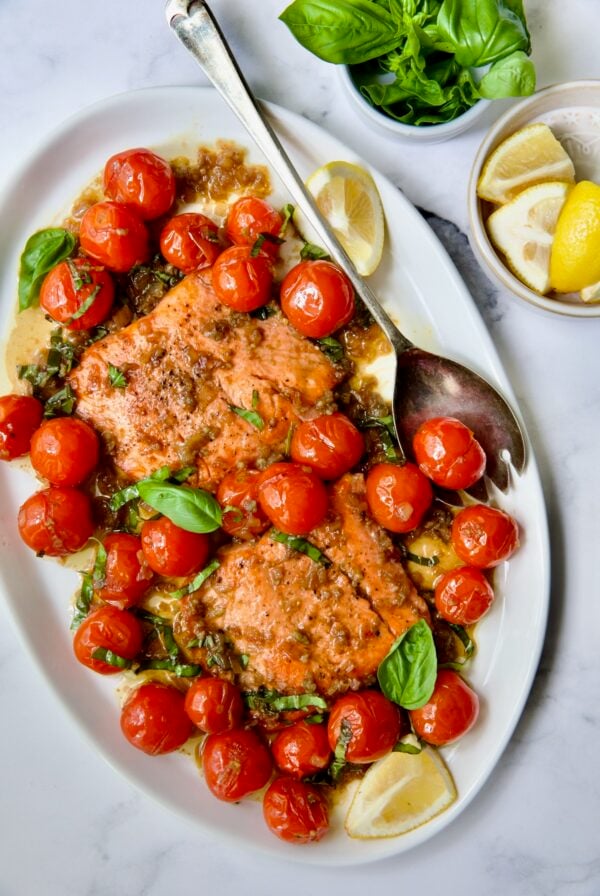 Salmon with Balsamic Cherry Tomatoes on oval white platter with serving fork.