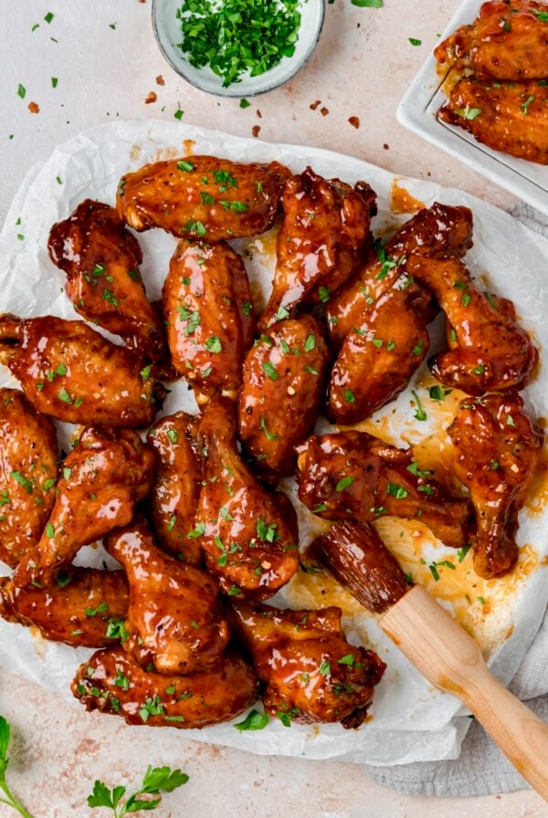 Hot Honey Chicken Wings on parchment paper lined platter with basting brush.