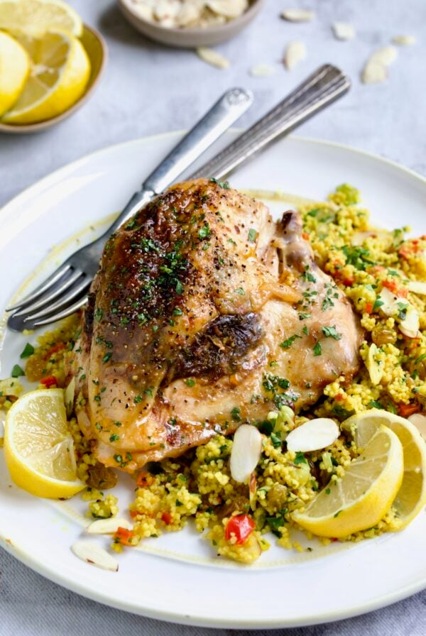 One serving of Moroccan Chicken with Jeweled Couscous on round white plate.