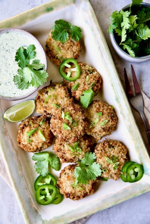 Thai Green Curry Shrimp Cakes on rectangular platter garnished with jalapeno slices and cilantro leaves.