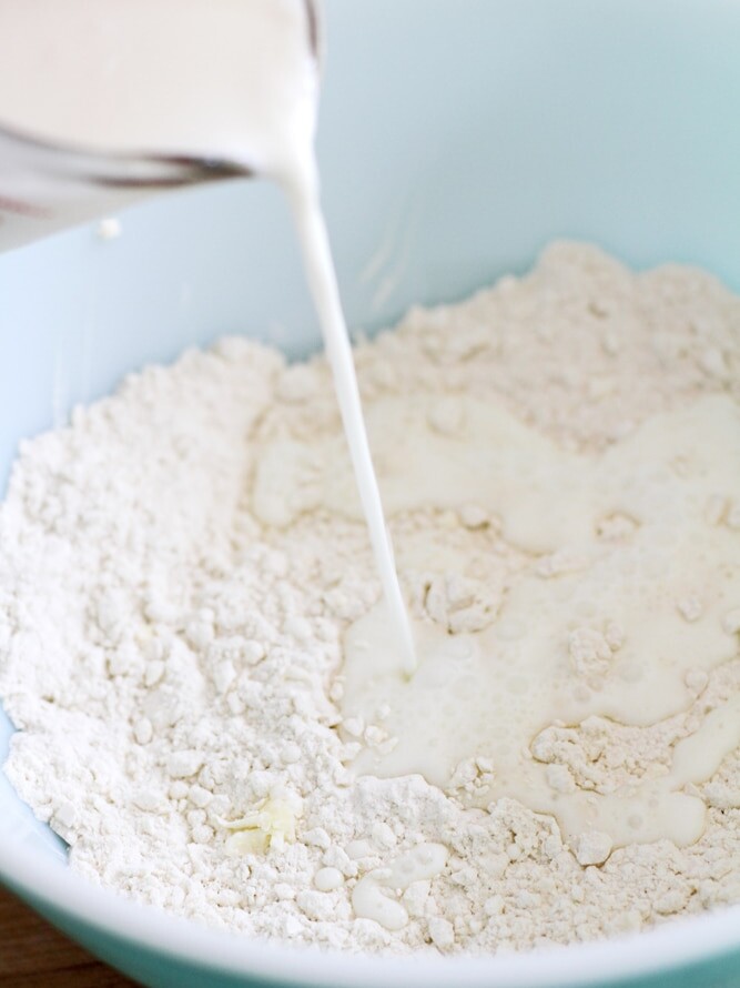 pouring buttermilk into flour mixture in bowl.