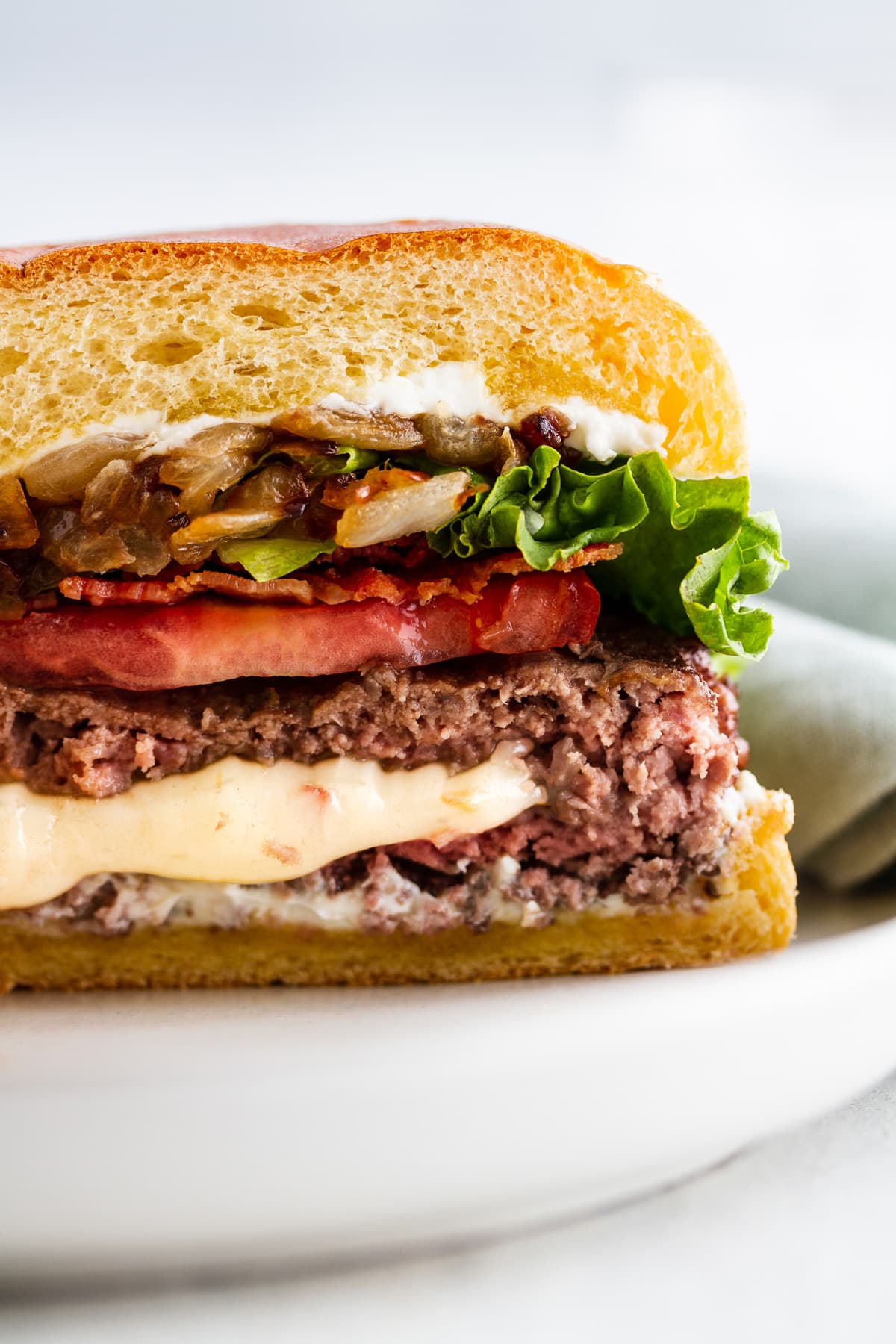 a close-up image of a pepper jack juicy lucy burger cut in half on a plate