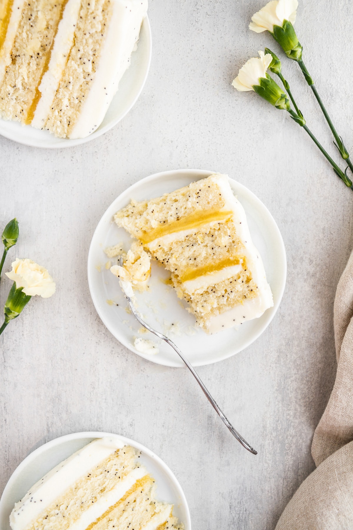 slices of lemon poppy seed cake on plates with a fork.