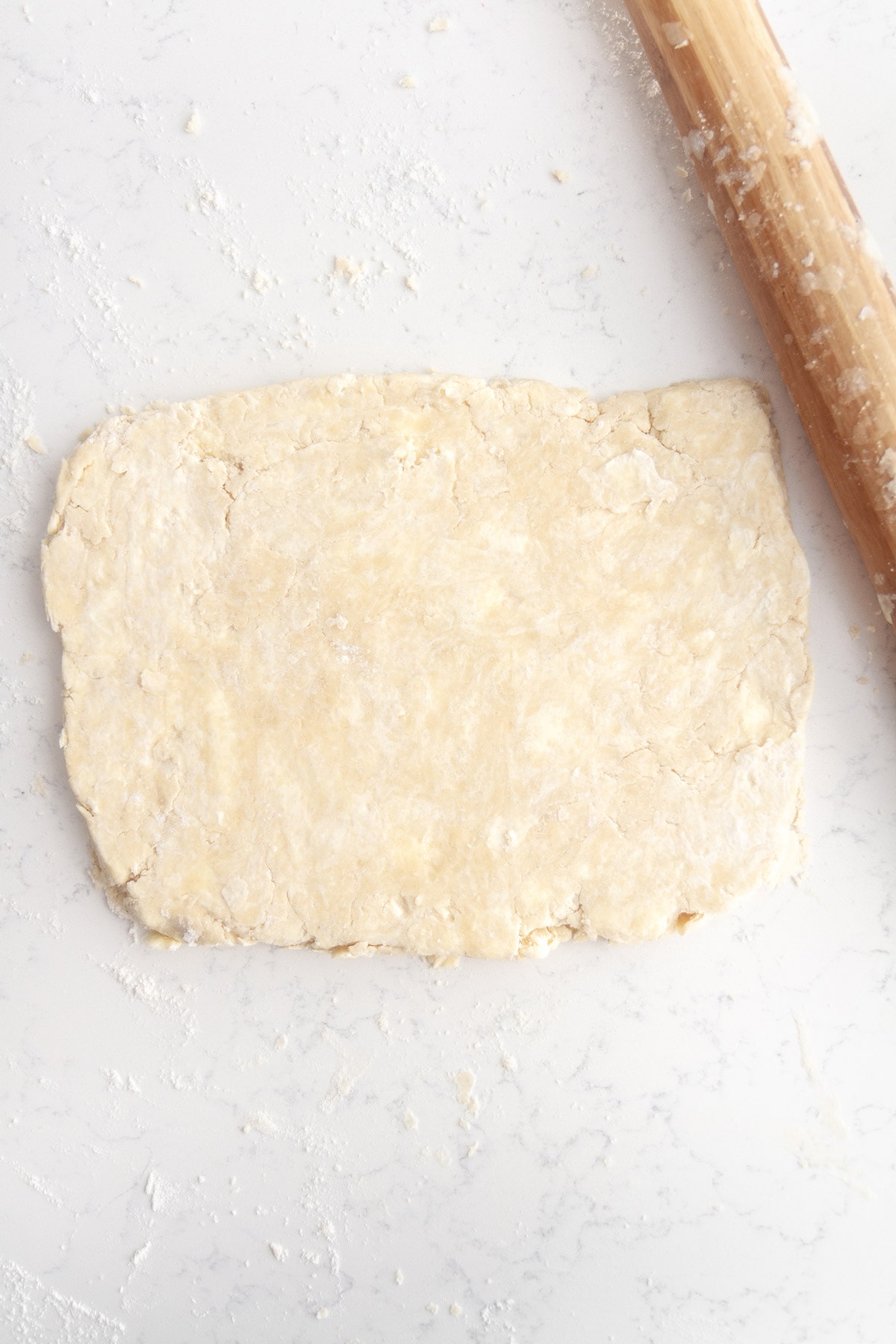 rough puff pastry dough rolled out onto a surface.