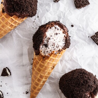 cookies and cream ice cream drumsticks on a surface.