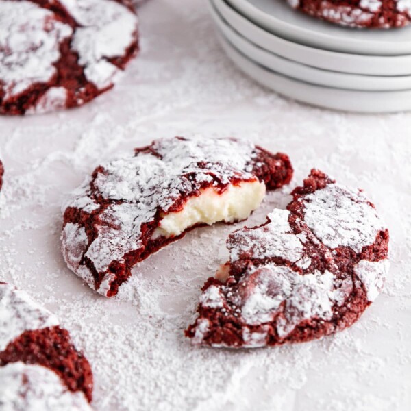 red velvet cookies on a surface covered with powdered sugar.
