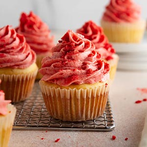 strawberry shortcake cupcakes on a cooling rack.