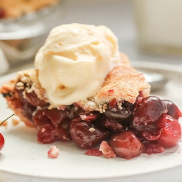 slice of cherry pie with ice cream on top.