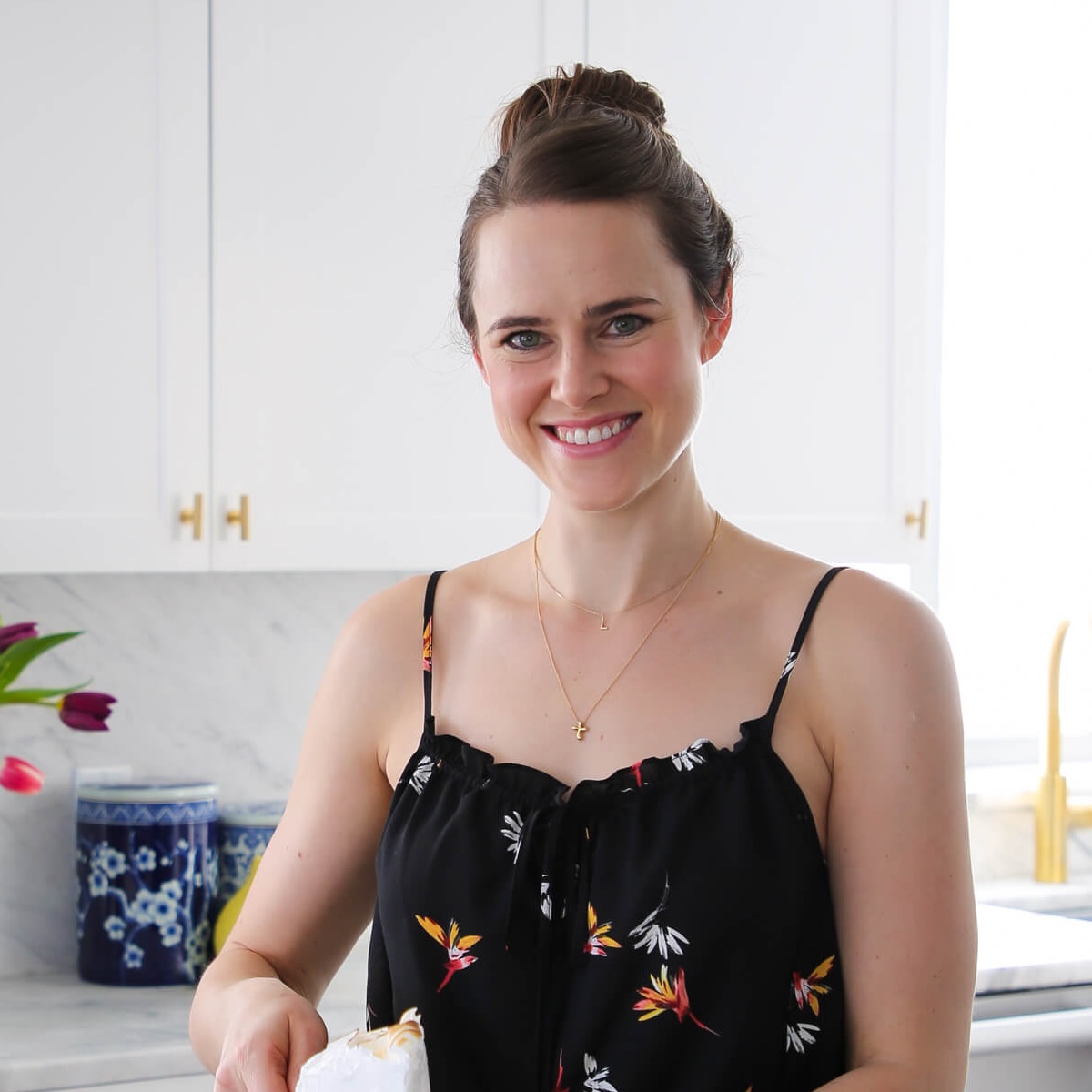 chef lindsey farr holding slice of cake.
