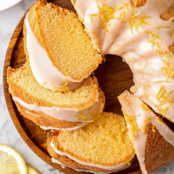 slices of lemon bundt cake arranged on wooden plate.