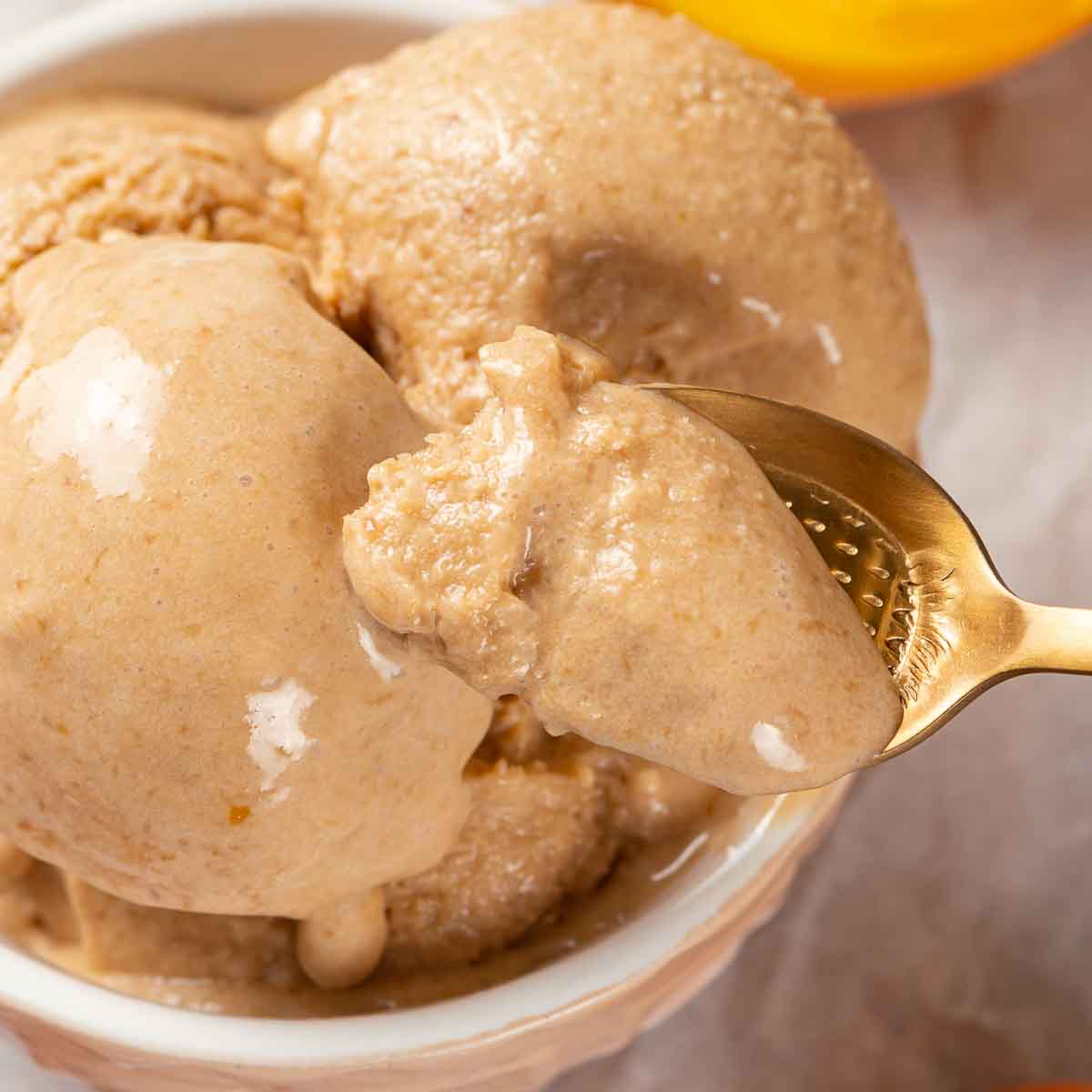 Peach ice cream with a gold spoon.
