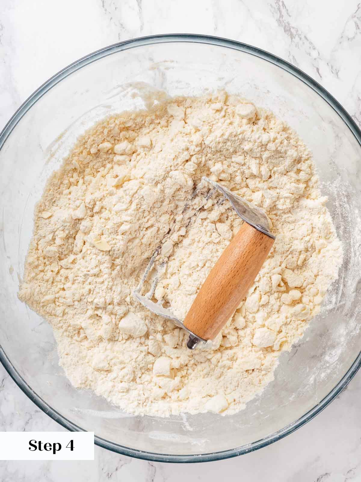 Butter being cut into the pie crust dough mixture.