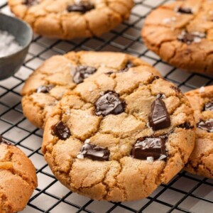 A close-up of a cookie showing melted chocolate pieces oozing out of its surface.