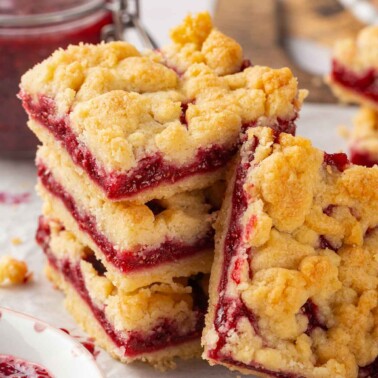 A cut section of raspberry crumble bars showing the rich, jammy raspberry filling and buttery crust.