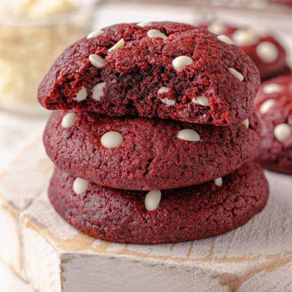A red velvet chocolate chip cookie with a bite taken out, revealing its soft, chewy interior.