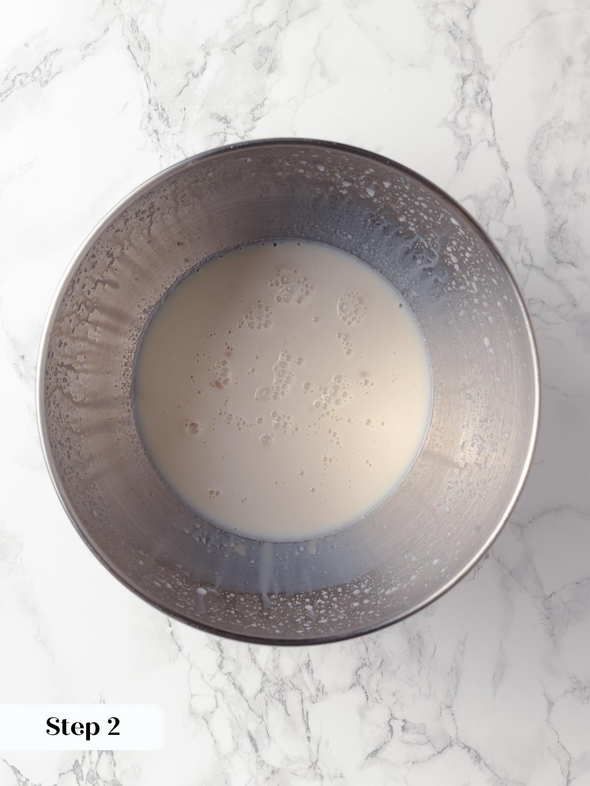 Milk and yeast mixture starting to bubble before mixing.