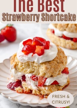 Homemade strawberry shortcake sliced in half and filled with whipped cream and berries.