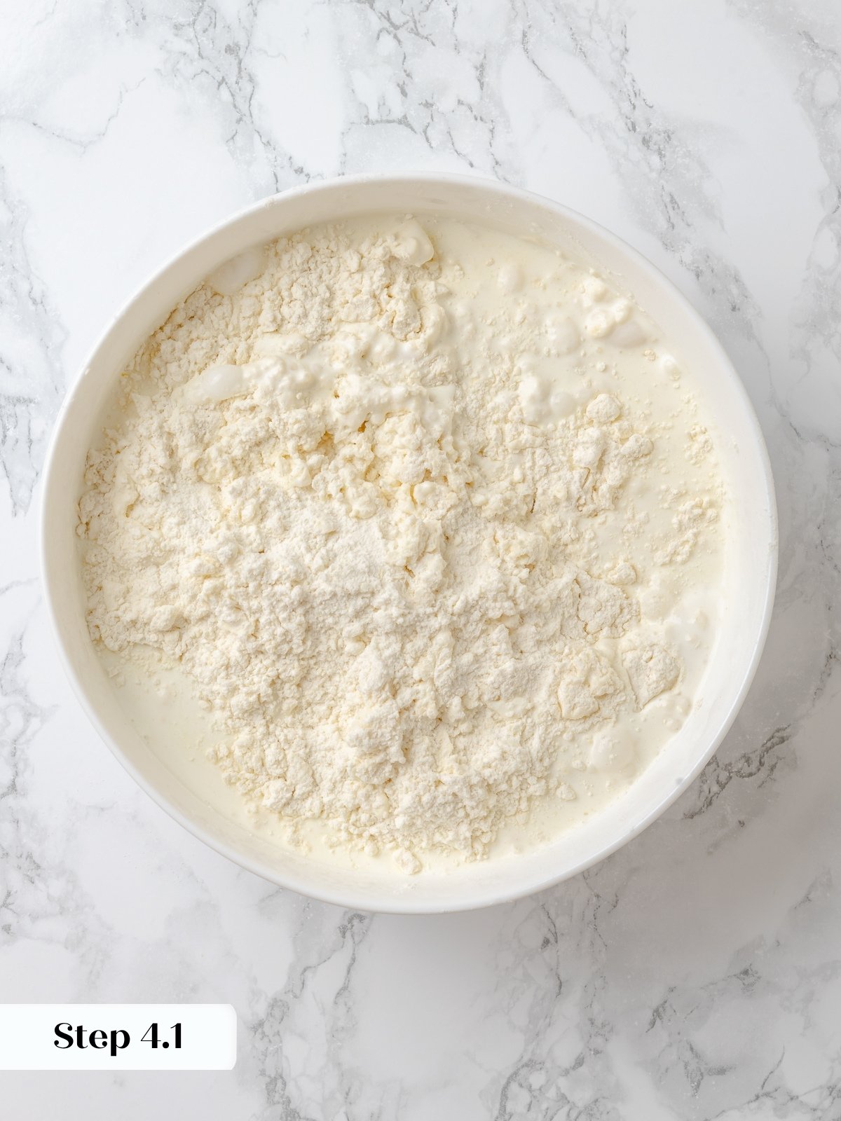 heavy cream poured into bowl of shortcake ingredients.