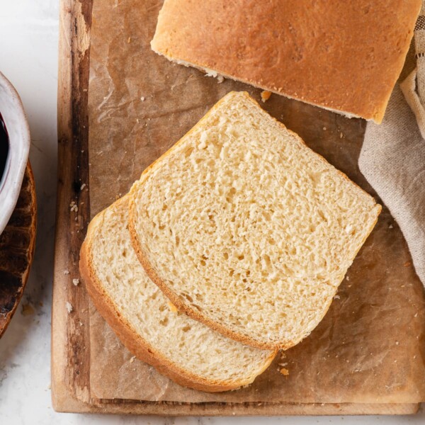 Two soft slices of sandwich bread are stacked to show the light and airy crumb.