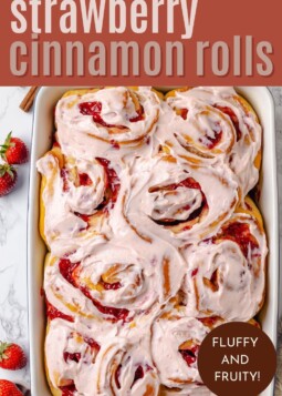 Baked strawberry cinnamon rolls in a buttered dish.