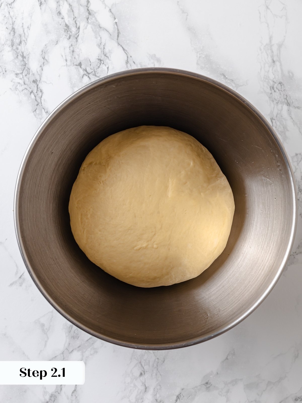 Strawberry cinnamon roll dough placed in a bowl to rise.