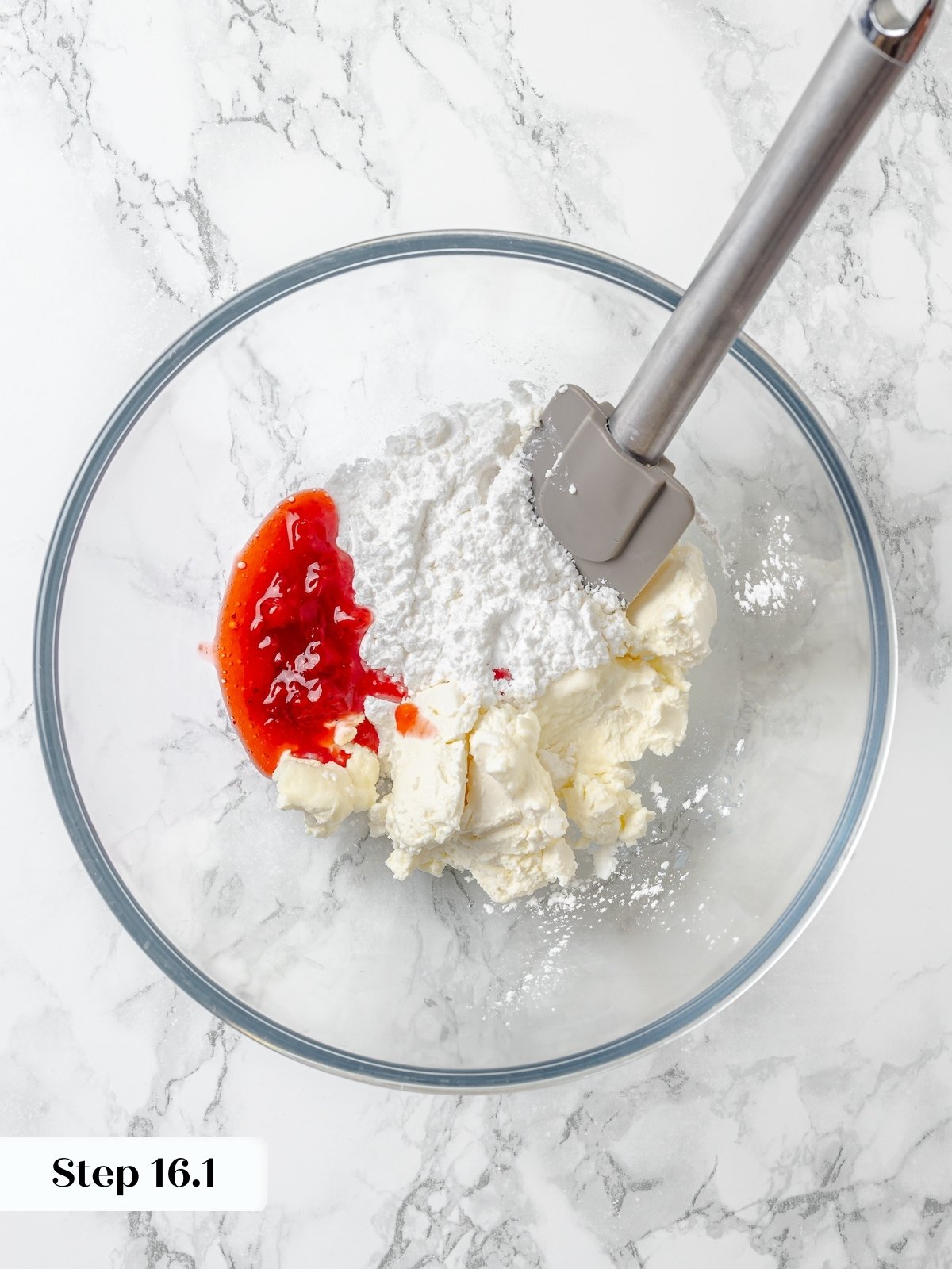 Strawberry cream cheese frosting ingredients in a clear glass bowl.