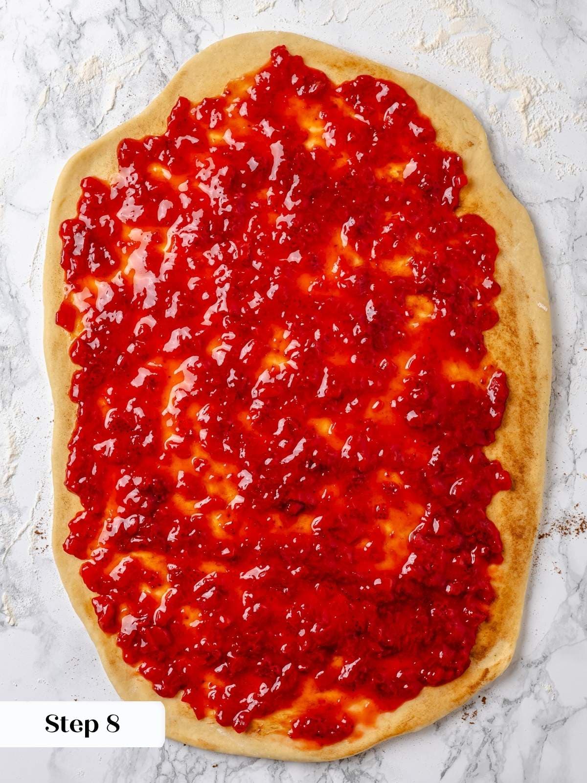 Dough covered in homemade jam before rolling.