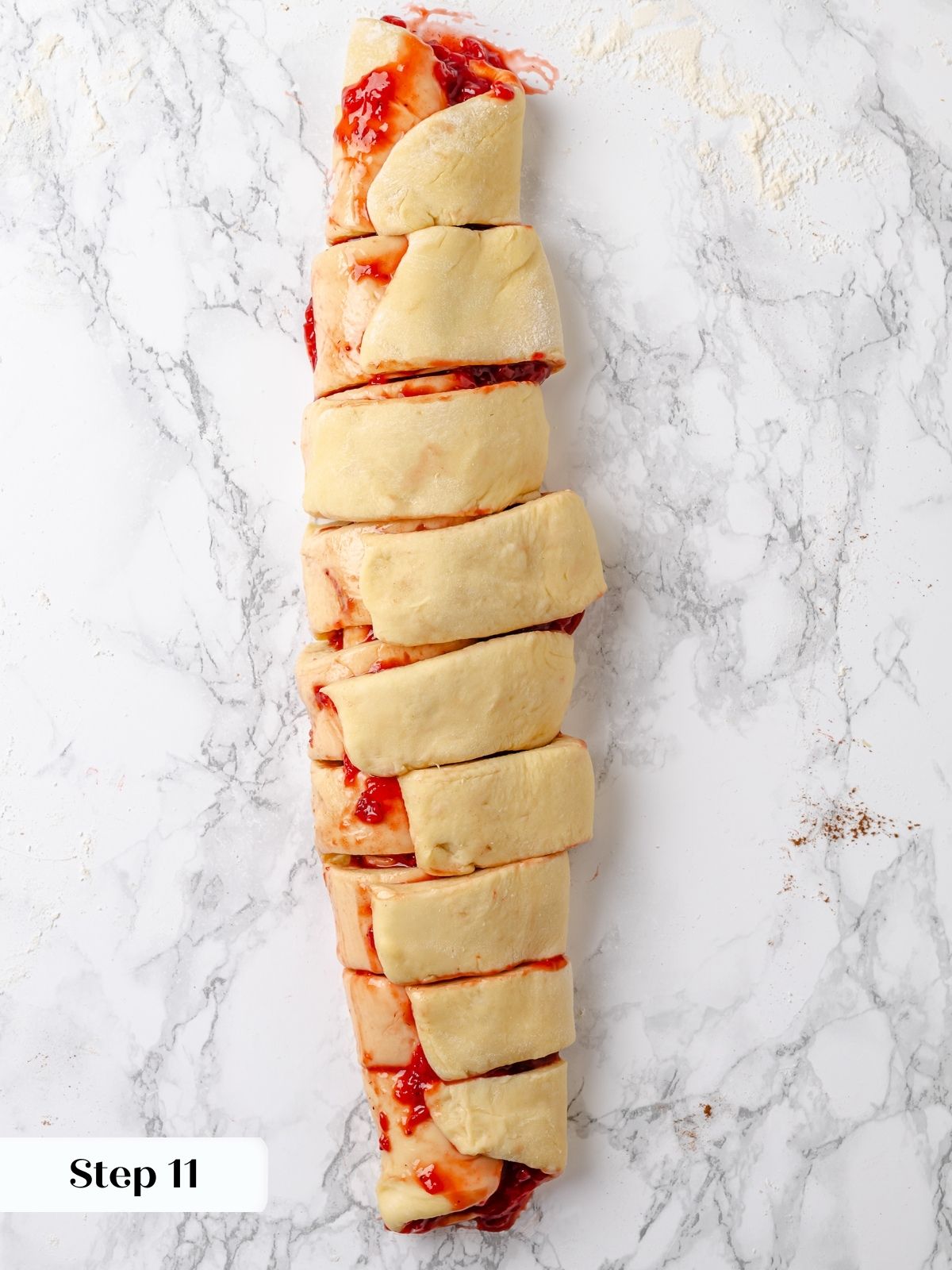Strawberry roll log cut into sections before baking.