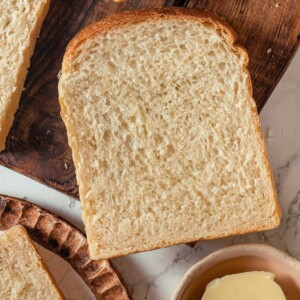 Single slice of sourdough sandwich bread showing soft crumb and golden brown crust.