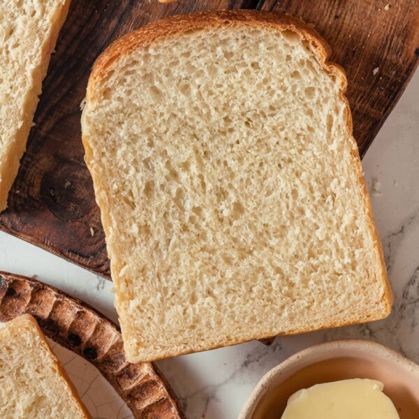Single slice of sourdough sandwich bread showing soft crumb and golden brown crust.