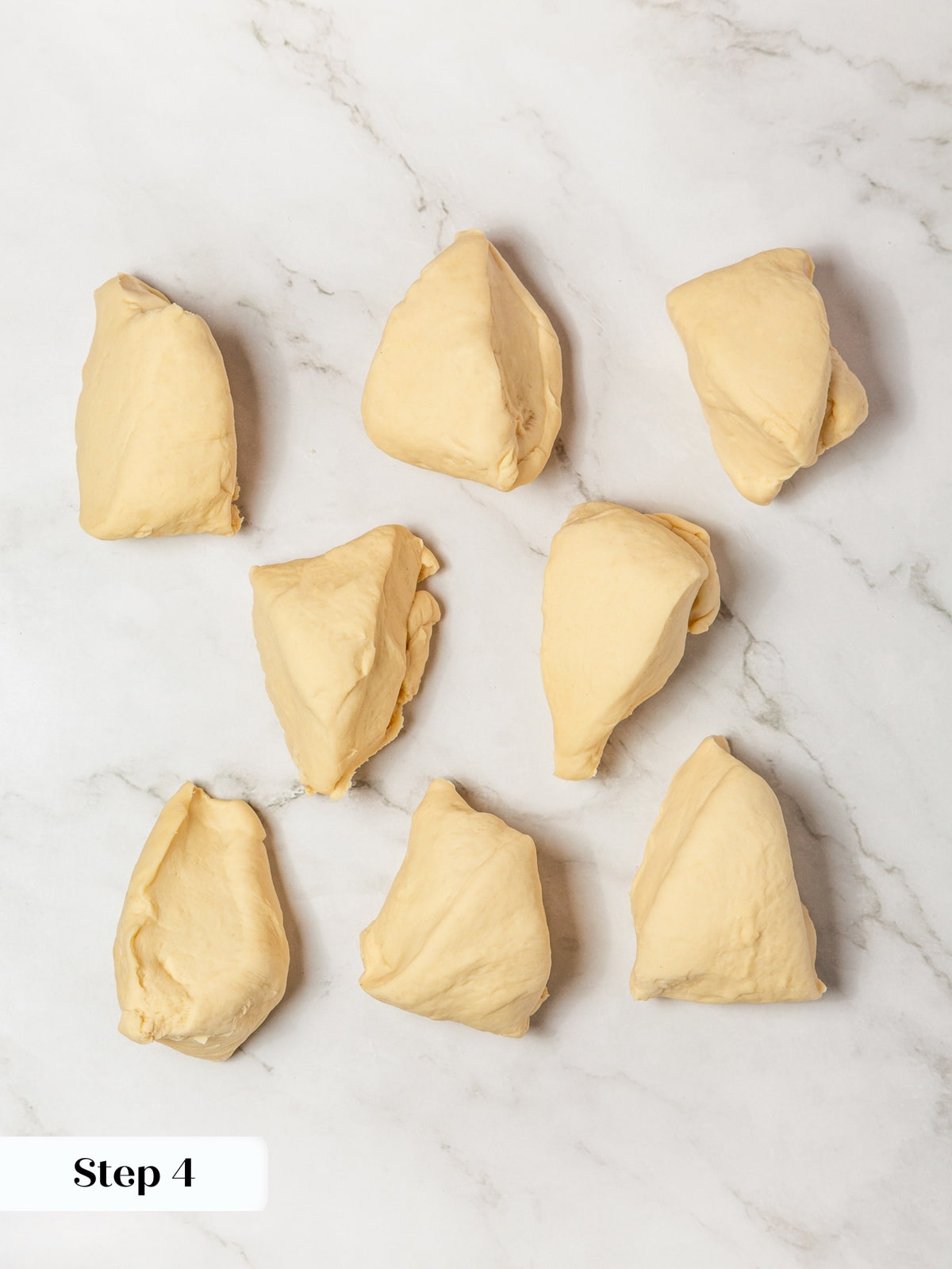 Eight dough portions arranged on the counter showing equal sizing for shaping bagels.
