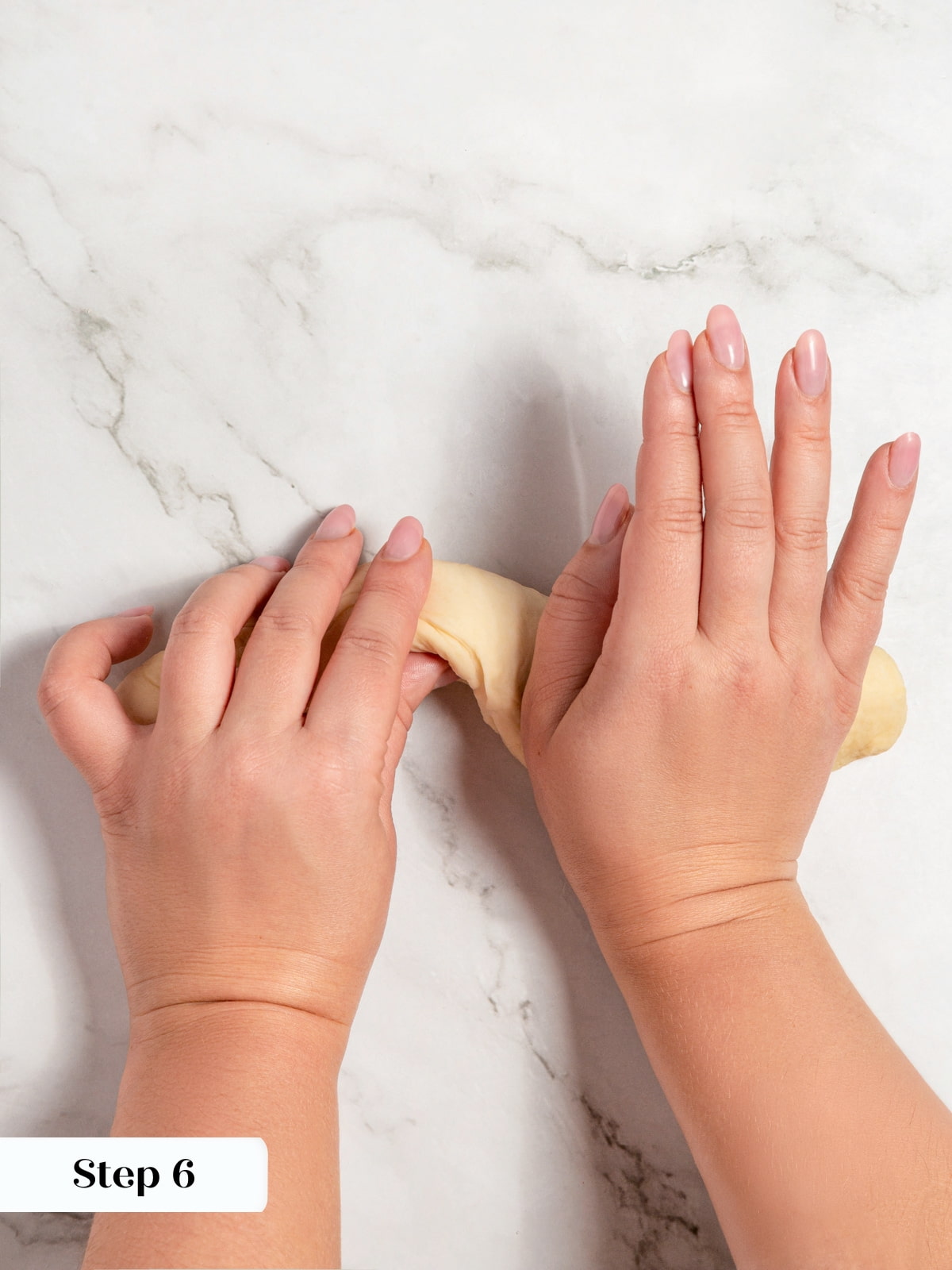 Dough shaped into a log through folding and pressing to create structure.