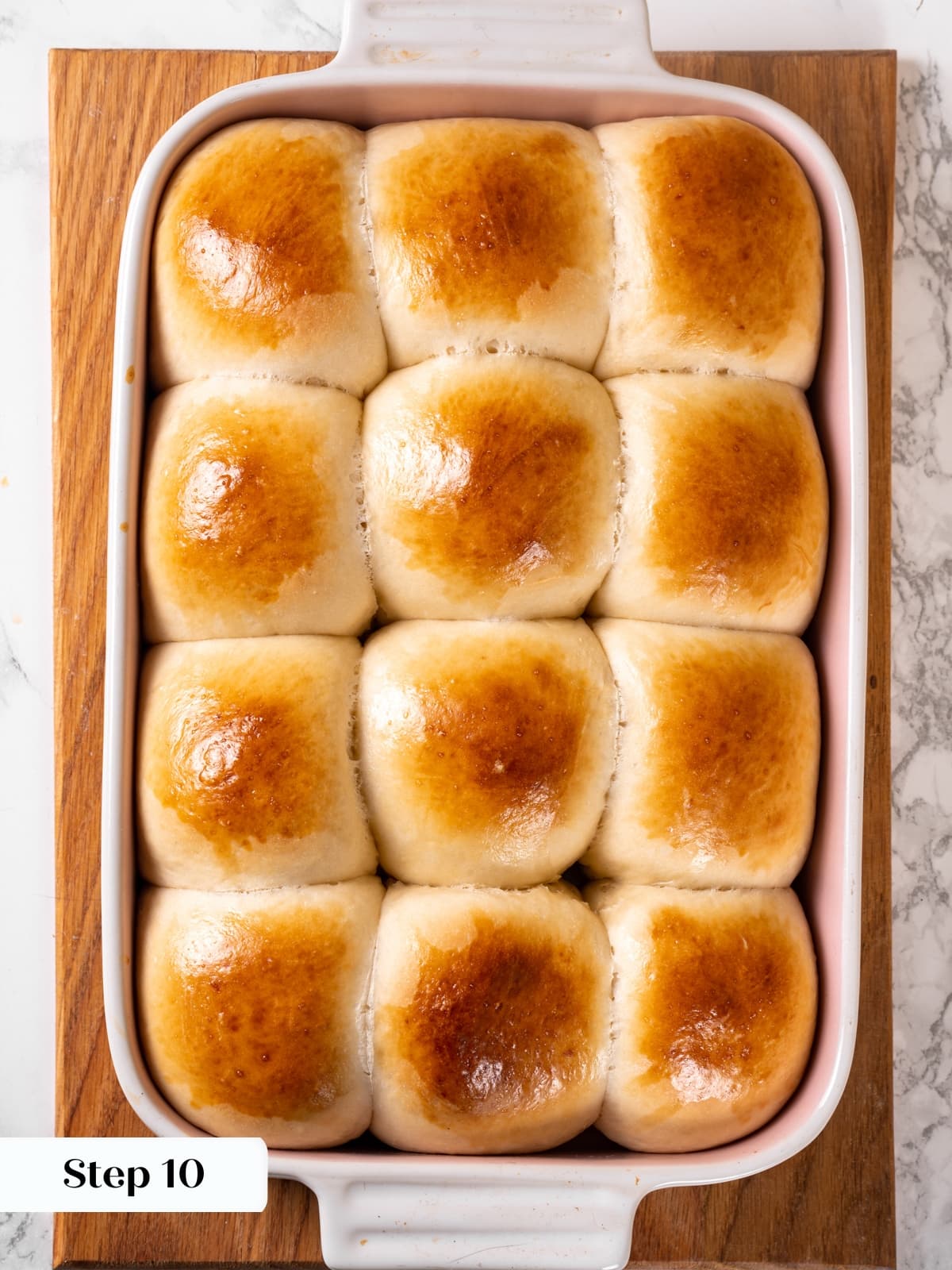 Completed sourdough rolls sitting together after baking with soft sides touching gently.