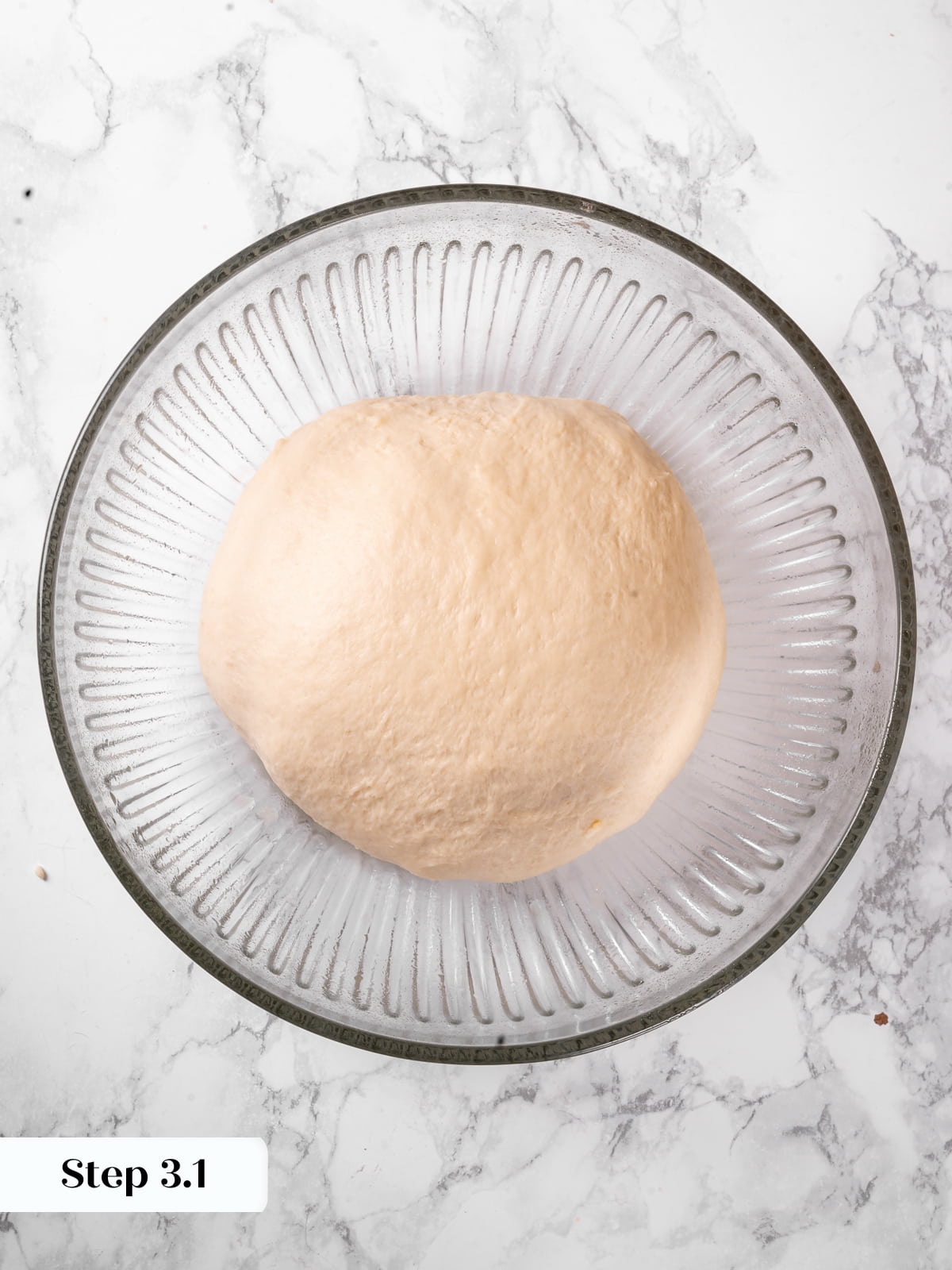 Freshly mixed dough resting in a bowl with a soft texture before rising.