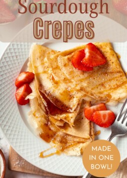 Sourdough crêpe topped with sliced strawberries and maple syrup, folded and ready to serve.