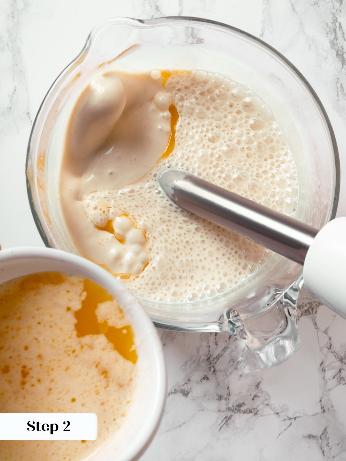 Butter poured into liquid sourdough batter during crêpe preparation.