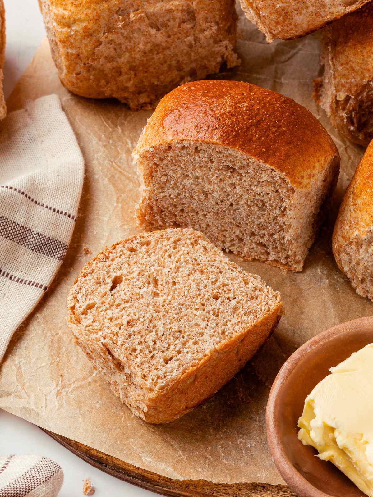 Whole wheat dinner roll sliced open revealing light airy crumb and tender interior.