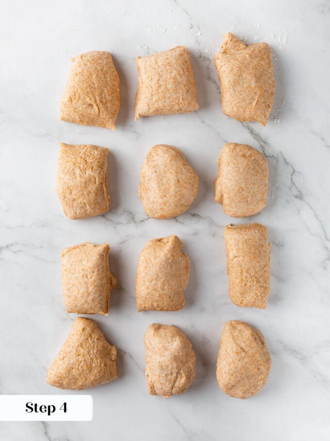 Dough divided into equal portions on countertop, ready to be shaped into rolls.