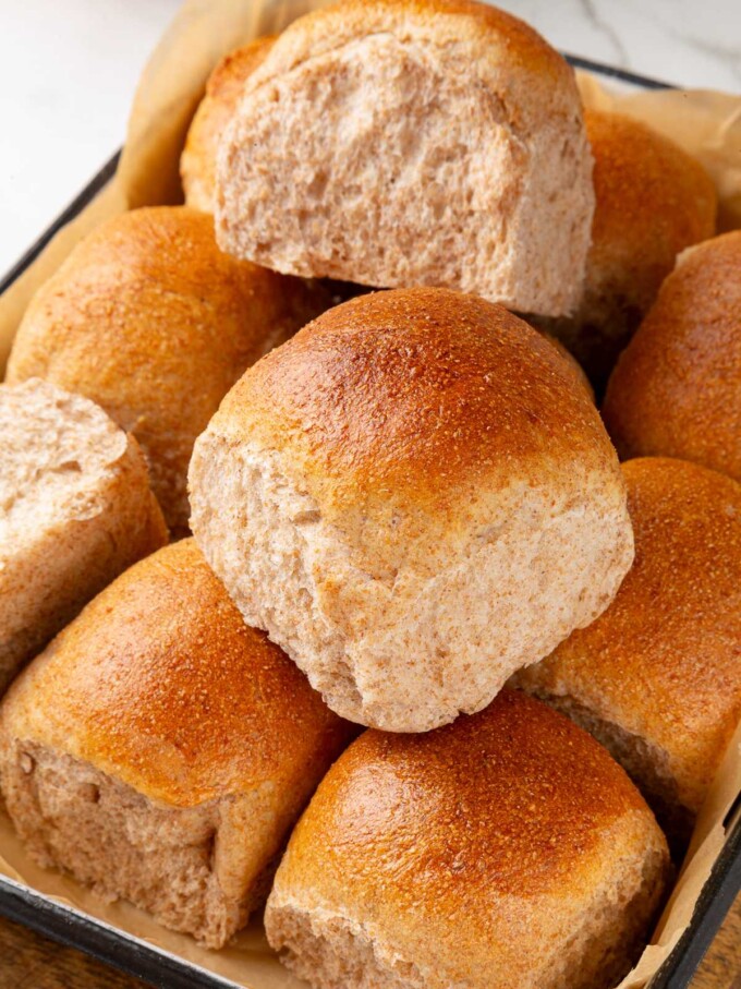 Several whole wheat sourdough rolls displayed together showing soft texture and golden crust.