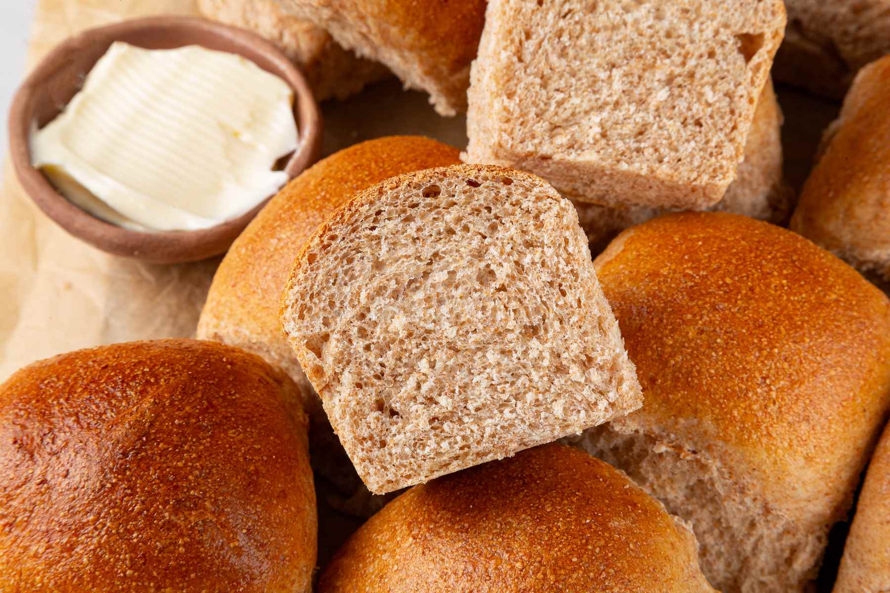 Tender crumb of whole wheat sourdough rolls showing soft, slightly moist interior texture.