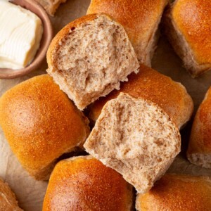Whole wheat sourdough roll torn open showing stretchy crumb and soft interior layers.