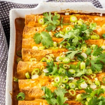 Vegetarian black bean enchiladas in a white casserole dish